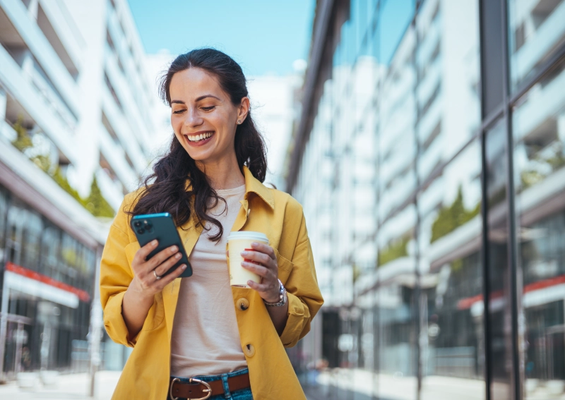 a woman looking at her mobile and smiling