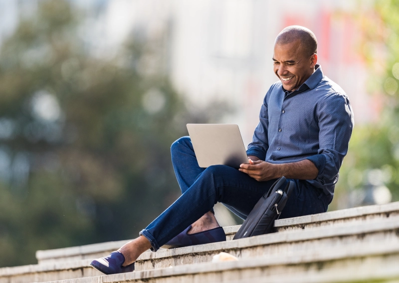 african-american-businessman-using-laptop-on-stairs